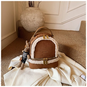 Detail view of brown suede backpack with faux shearling trim and cute rabbit pendant