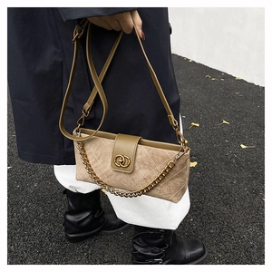 Detail of tan suede crossbody bag with quilted patterns and vintage gold chain