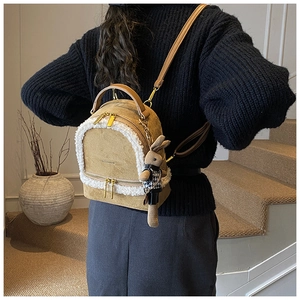 Detail of plush winter backpack in beige with faux lamb wool trim and rabbit doll charm
