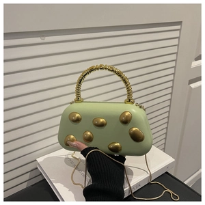 Detail of light green bag with geometric gold metal accents and sculptural handle