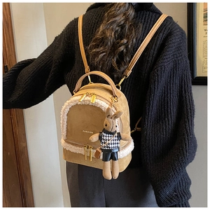 Detail of brown suede mini backpack with plush fleece trim and cute rabbit pendant charm