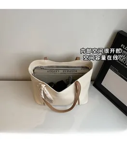 Top view of large capacity white tote bag showing spacious interior with laptop and books