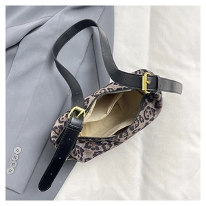 Detailed interior of leopard print crossbody bag showing zipper pocket and adjustable strap