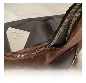 Close-up of vintage suede tote bag with metal rivets and herringbone pattern lining