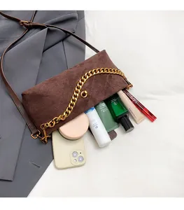 Detail of brown quilted suede crossbody bag showing interior storage for cosmetics