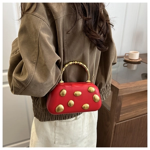 Red structured evening bag with artistic gold metal dots and chic chain strap detail