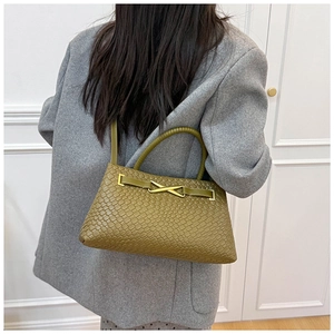 Détail du sac vert olive à texture tressée doté d'une boucle en métal doré en forme de X