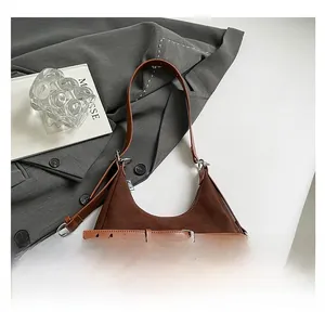 Dettaglio borsa sottobraccio in pelle opaca marrone scuro con fibbie vintage e dettagli argento