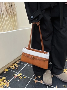 Gros plan du sac baguette en cuir marron avec bordure en peau de mouton et boucle métal