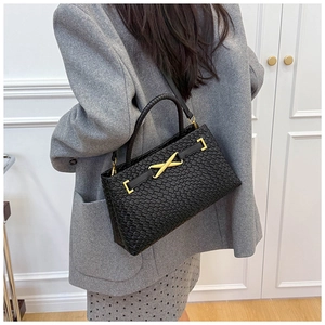 Détail de la texture tressée et du fermoir doré sur le sac à main rétro noir
