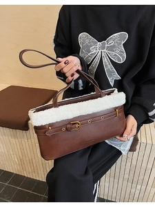 Gros plan du sac en cuir marron avec bordure en fausse fourrure blanche et gravure