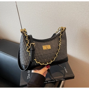 Détail du sac pied-de-poule avec fermoir doré et bordures en cuir noir