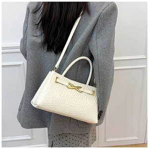 Détail du sac panier tressé blanc avec fermoir doré et poignée élégante