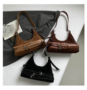 Dettaglio di tre borse sottobraccio in pelle scamosciata con fibbie in stile vintage