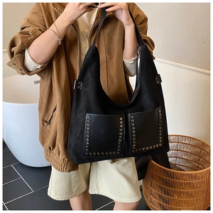 Détail du sac cabas noir avec deux poches avant ornées de rivets métalliques élégants