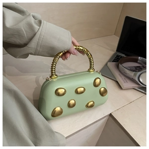 Detail of light green underarm bag with gold spiral handle and pebble accents