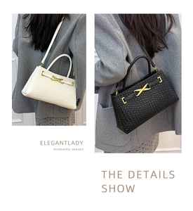 Détail du sac à main en cuir tressé avec boucle métallique dorée distinctive en forme de X