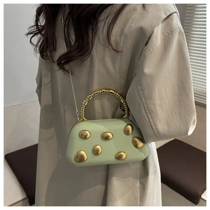 Detailansicht der minzgrünen Handtasche mit goldenen Nieten und Perlen-Handgriff-Design