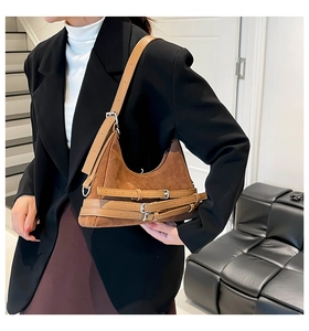 Borsa sottobraccio in pelle scamosciata marrone con cinturini decorativi indossata da modella
