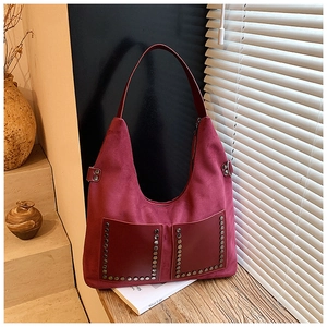 Détail du sac cabas en daim bordeaux avec poches frontales et rivets métalliques décoratifs
