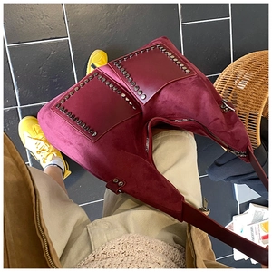 Détail du cabas en daim bordeaux avec rivets métalliques et poches avant dans un style urbain