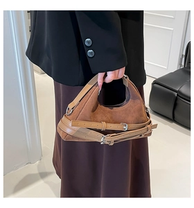 Dettaglio della borsa sottobraccio in pelle scamosciata caramello con fibbie vintage