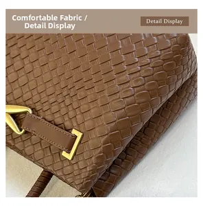 Gros plan sur la texture tissée marron et les détails dorés mats d'un sac à main chic