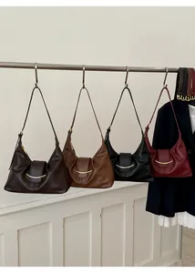 Détail de quatre sacs hobo en cuir marron foncé, caramel, noir et bordeaux avec boucles dorées