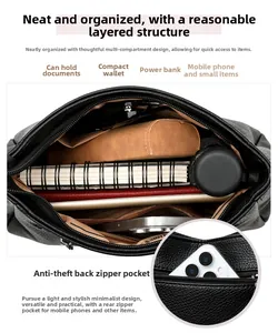 Detail view of large black leather tote bag featuring multiple interior compartments and theft-proof pocket