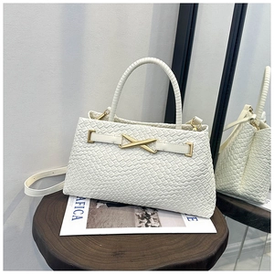 Gros plan sur la texture tressée blanche et le fermoir métallique en X de ce sac