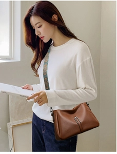 Detail of dark brown lychee leather crossbody bag with ethnic patterned wide strap