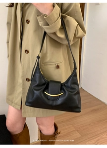 Détail du sac hobo en cuir noir souple avec boucle dorée en forme de croissant