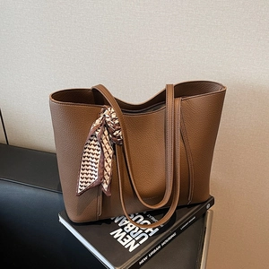 Brown pebble leather tote bag with geometric silk scarf and elegant gold lettering