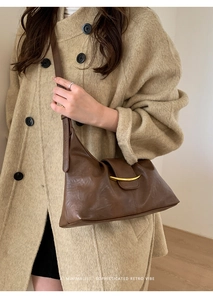 Détail du sac bandoulière marron rétro avec boucle en métal doré et lanière