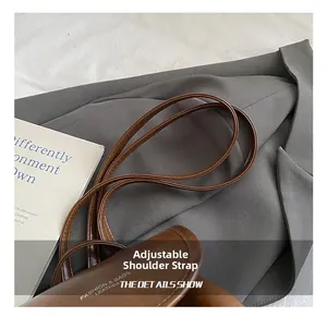 Detail of adjustable leather shoulder strap on a brown minimalist commuter backpack