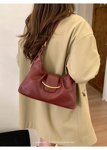 Détail du sac demi-lune bordeaux avec boucle en métal doré et style rétro élégant