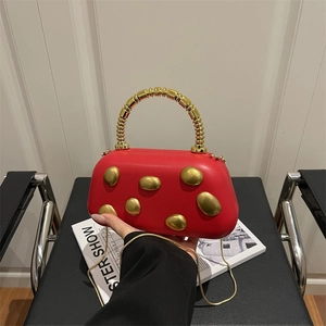 Red leather underarm bag with gold beads handle and metallic studs for evening wear