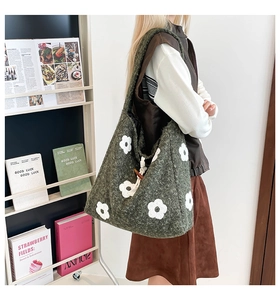 Detail of green tweed shoulder bag with white flower patterns and wooden button closure