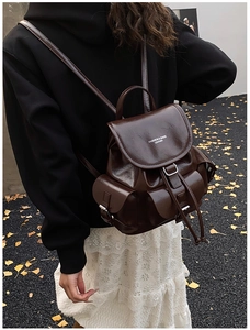 Detail of dark brown vintage PU leather backpack with drawstring closure and front pockets