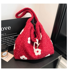 Detail of red wool tote bag with white flower patterns and wooden horn buckle closure