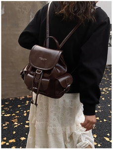 Deep brown faux leather backpack detail showing drawstring closure and silver buckle