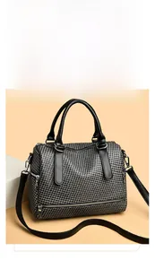 Detail of houndstooth fabric texture and silver hardware on a mini boston bag