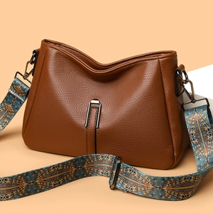 Brown textured leather shoulder bag with colorful geometric woven wide strap in V-shape design