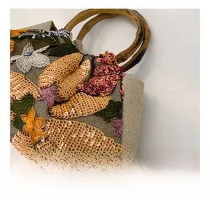 Detail of floral embroidery and sparkling sequins on a bamboo handle handbag
