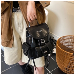 Detailed shot of black vintage leather backpack featuring metal buckles and multiple pockets
