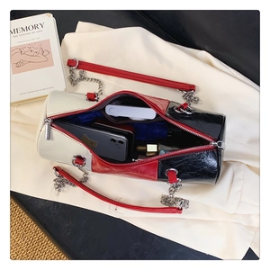 Internal capacity of tricolor cylinder bag showing space for phone and makeup