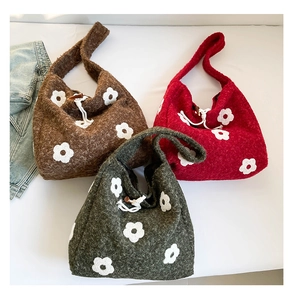 Detailed view of fleece shoulder bags with floral patterns and wooden button closures