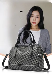 Macro detail of the houndstooth pattern bag with silver hardware and zippers