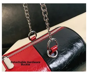 Detailed close-up of detachable silver hardware and glossy wrinkled texture on the barrel bag