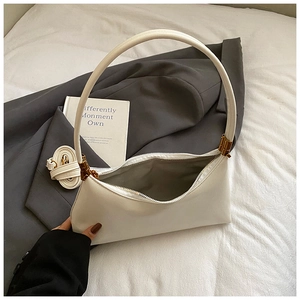 Détail du sac demi-lune blanc avec finitions dorées et deux bandoulières amovibles